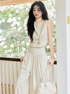 Cream high-rise wide-leg pants with elasticated waist and side pockets.