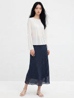 Navy polka dot A-line midi skirt with gathered waist and flared hem.