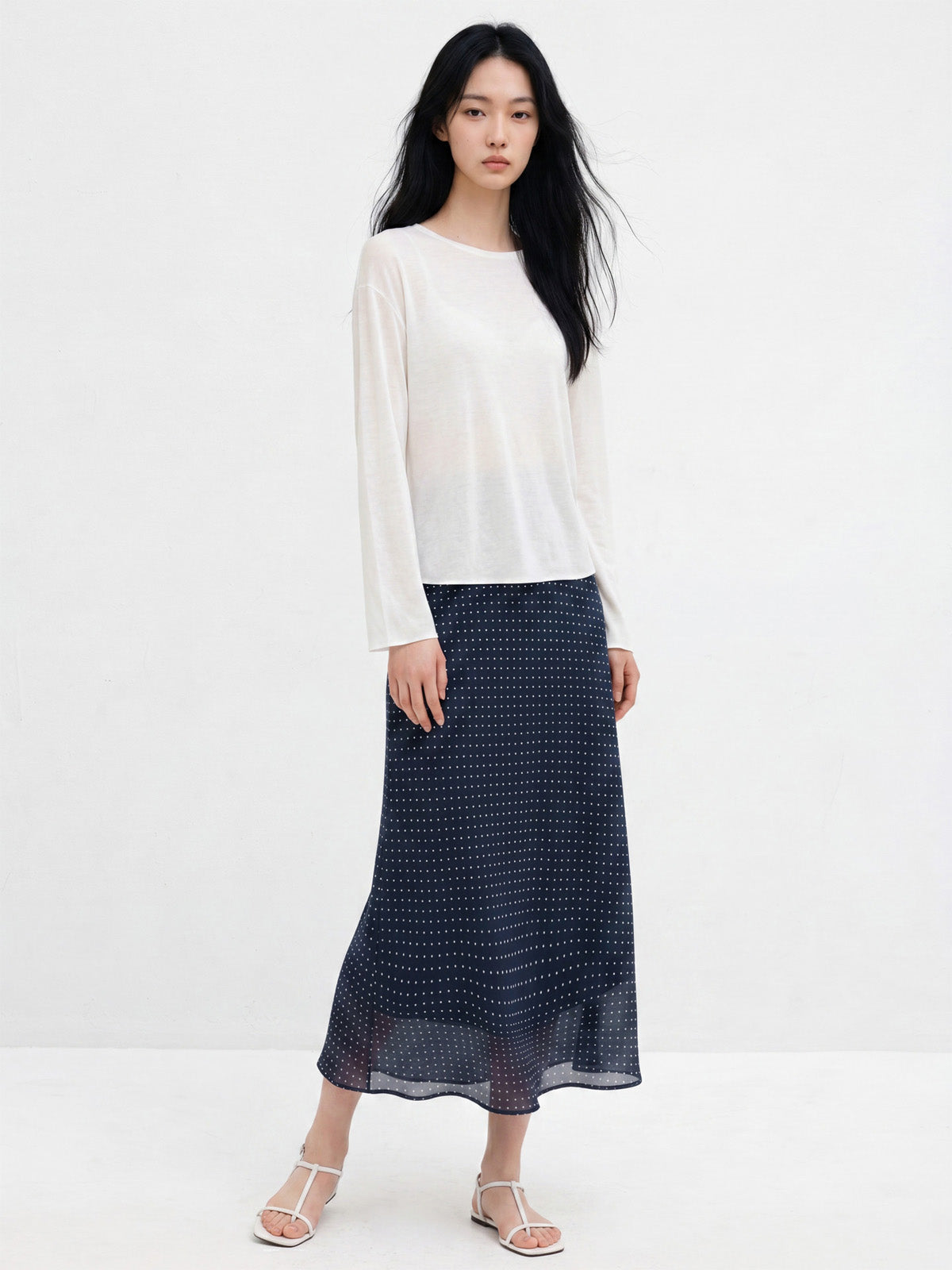 Navy polka dot A-line midi skirt with gathered waist and flared hem.
