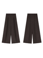 Dark brown high-rise wide-leg trousers with front pleats and button closure, shown from the front.