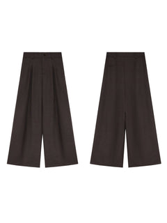 Dark brown high-rise wide-leg trousers with front pleats and button closure, shown from the front.