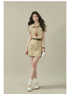 Beige short-sleeve shirt dress with collar, button placket, and two chest pockets.