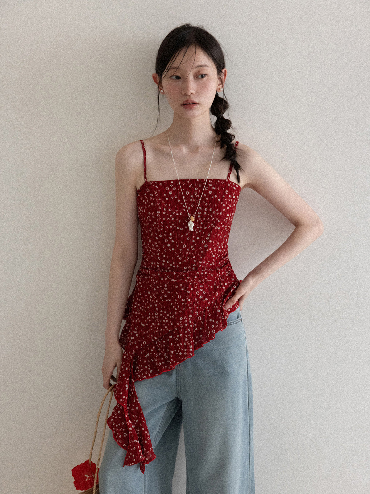 Red floral tank top with thin straps and asymmetrical ruffled hem.