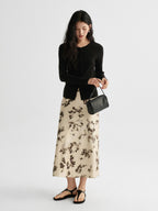 Ivory floral A-line midi skirt with pleated fishtail hem and high waist.