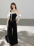 Black off-shoulder ruffled top with polka dot fabric straps.