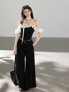 Black off-shoulder ruffled top with polka dot fabric straps.