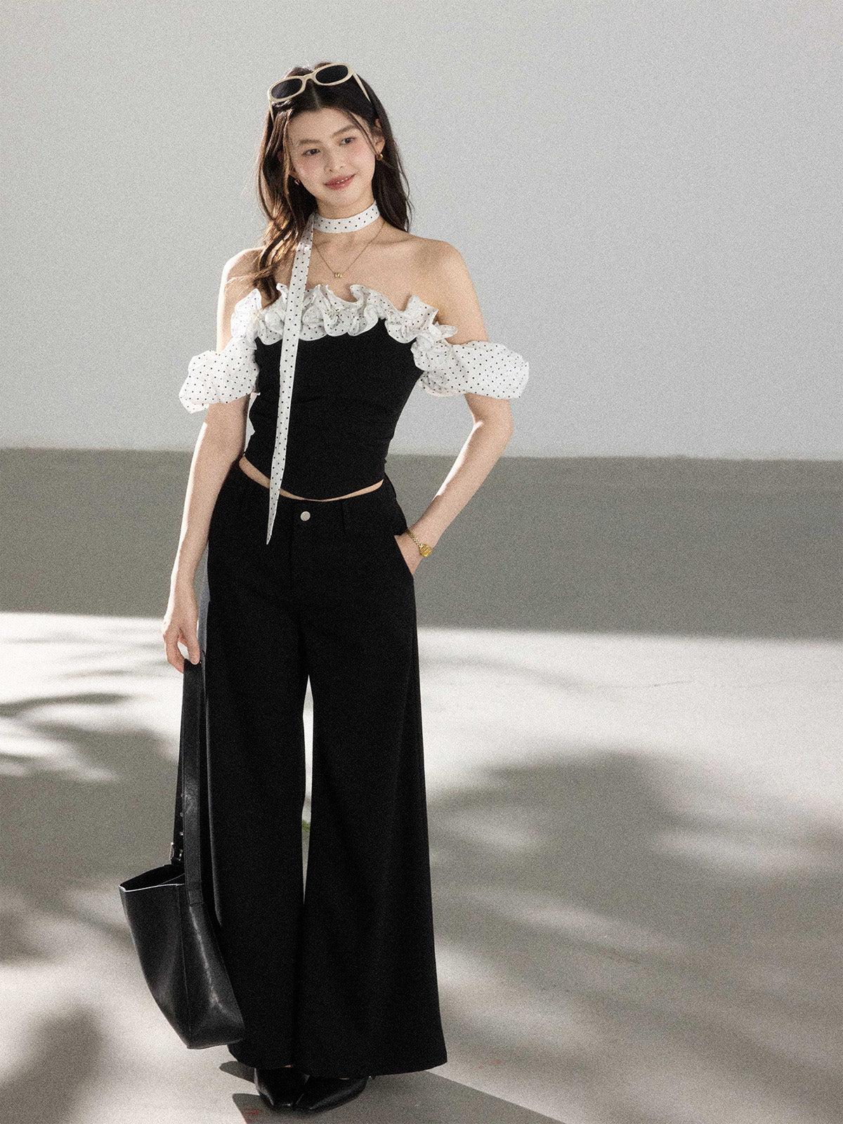 Black off-shoulder ruffled top with polka dot fabric straps.