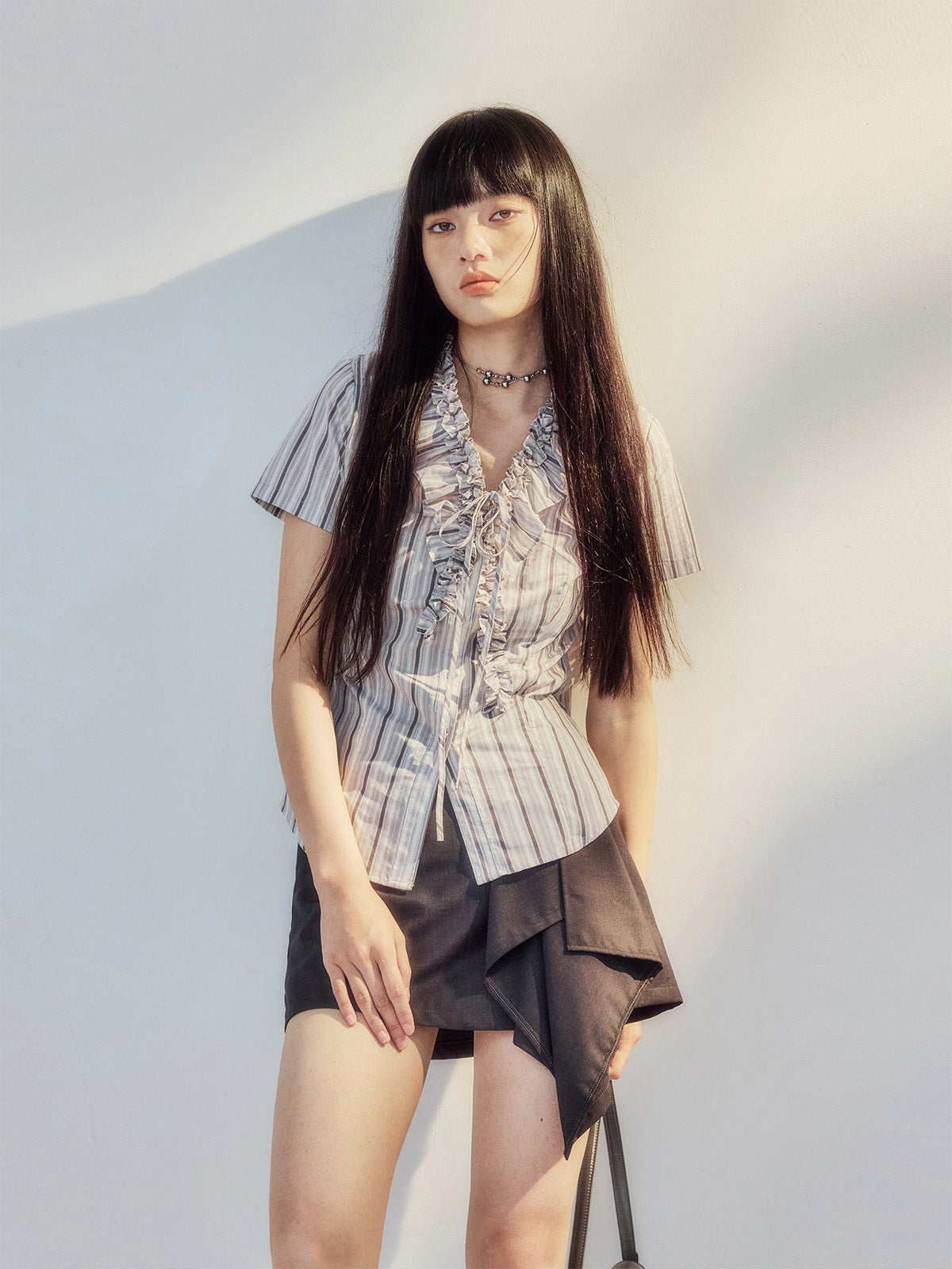 Grey purple striped blouse with ruffle trim and front tie detail.
