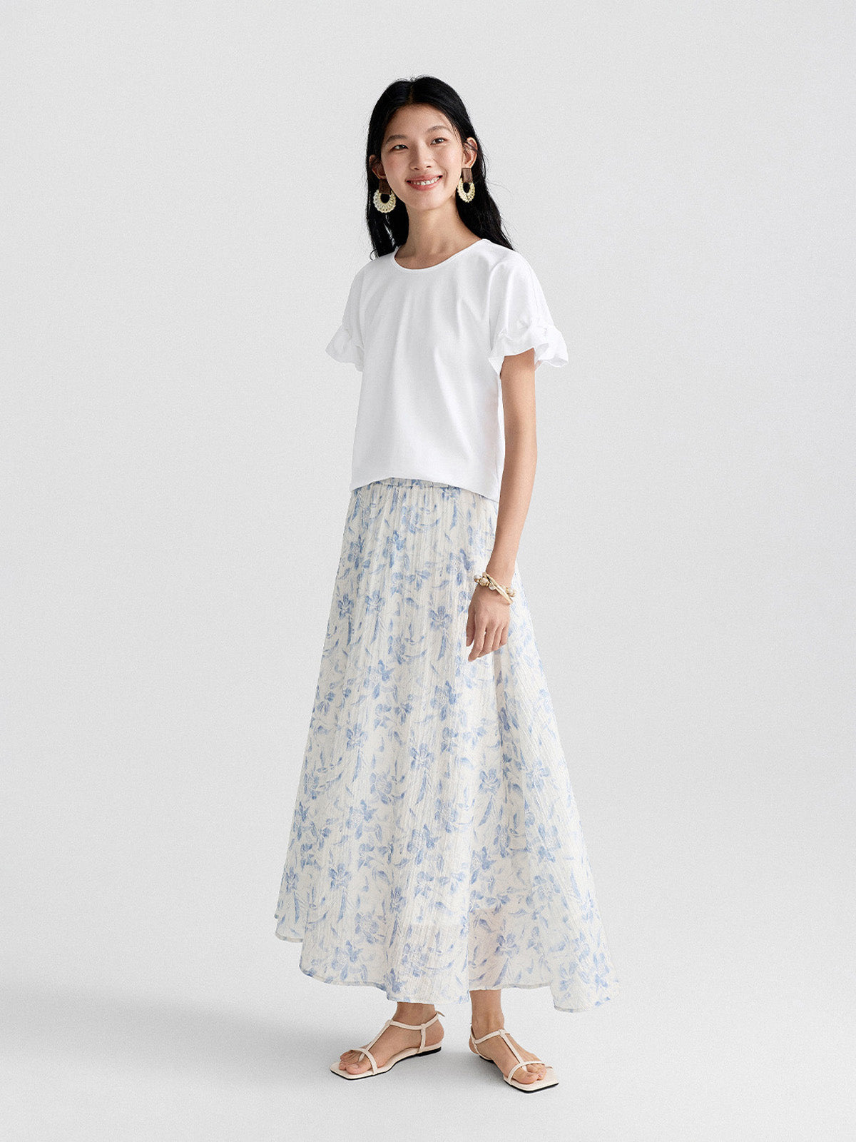 Blue floral A-line pleated skirt with elastic waist, white background.