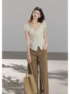 A cream polka dot fitted top with puff short sleeves and a drawstring front closure.