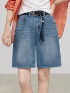 Light blue high rise denim shorts with straight hem and black belt.