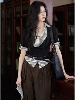 A woman wears a black and white striped layered V-neck top with short sleeves and a cowl neck.