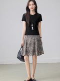 Leopard print pleated midi skirt with asymmetrical hem and high waist.