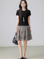 Leopard print pleated midi skirt with asymmetrical hem and high waist.