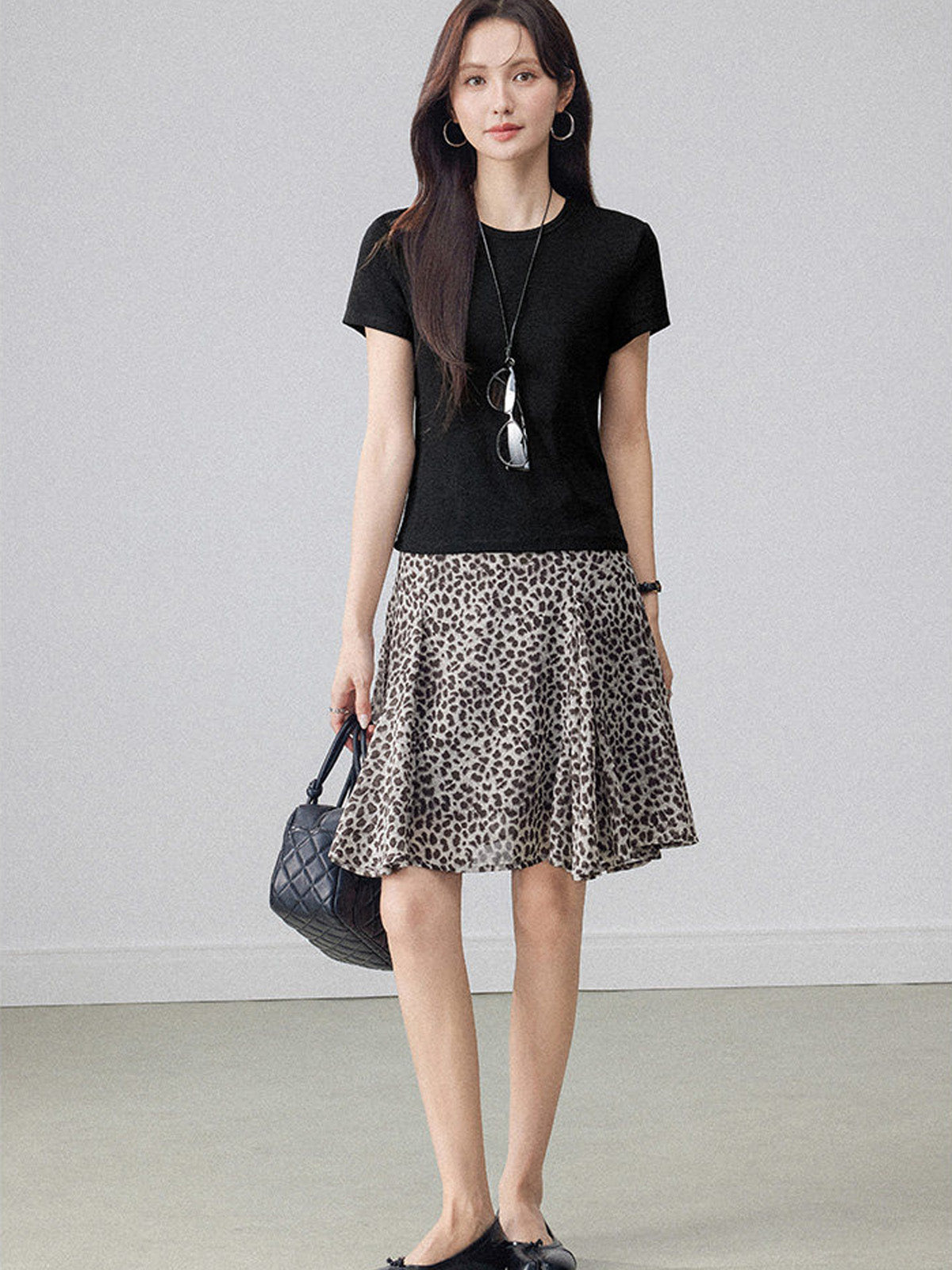 Leopard print pleated midi skirt with asymmetrical hem and high waist.
