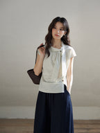 Ivory stripe short sleeve blouse with asymmetrical tie detail and button closure.