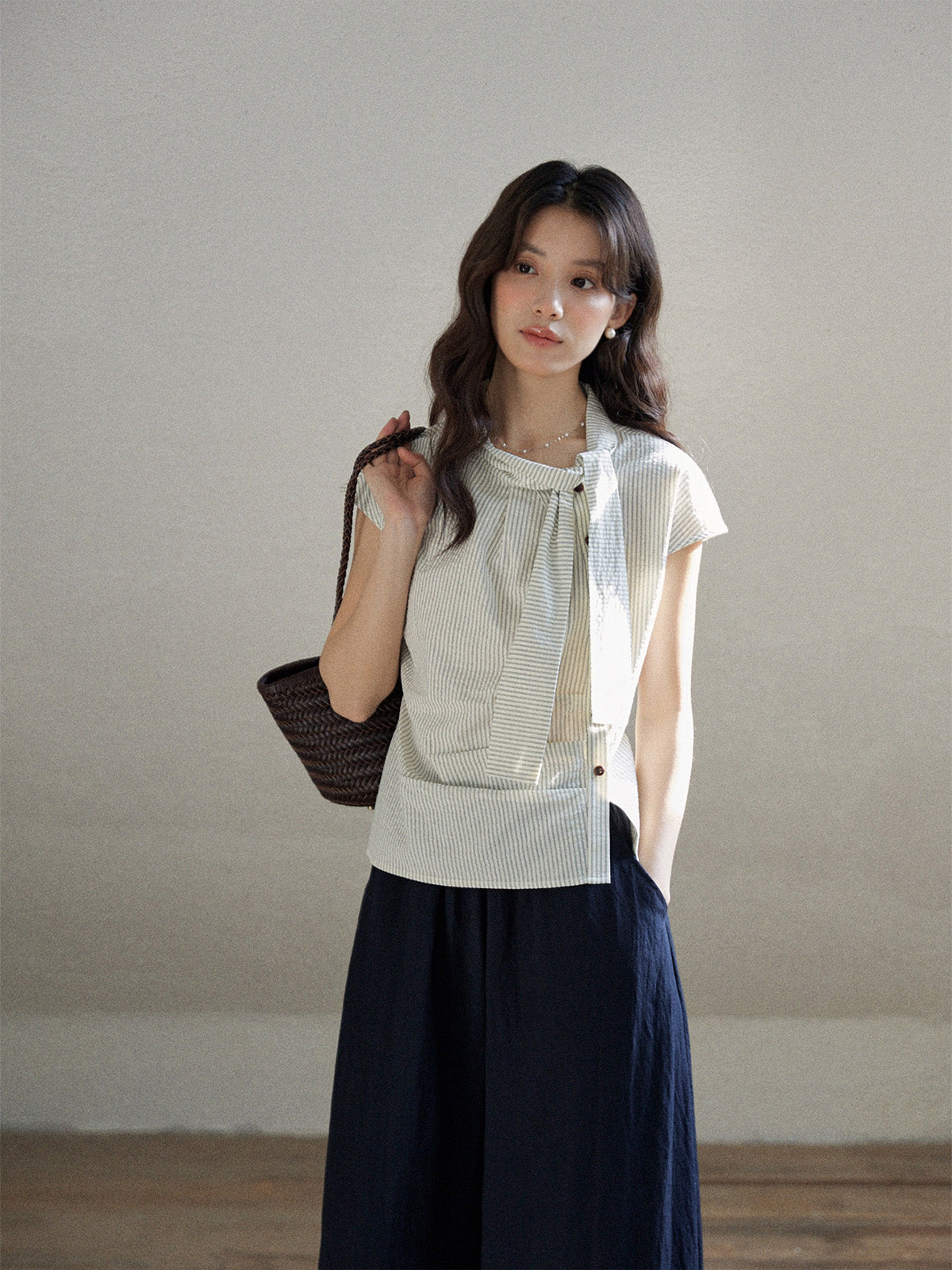 Ivory stripe short sleeve blouse with asymmetrical tie detail and button closure.