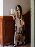 A woman wearing a long, sleeveless dress with a brown and beige patchwork pattern and a halter neckline.