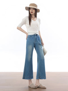 High rise light blue flared jeans with scalloped hem and embroidered stars.