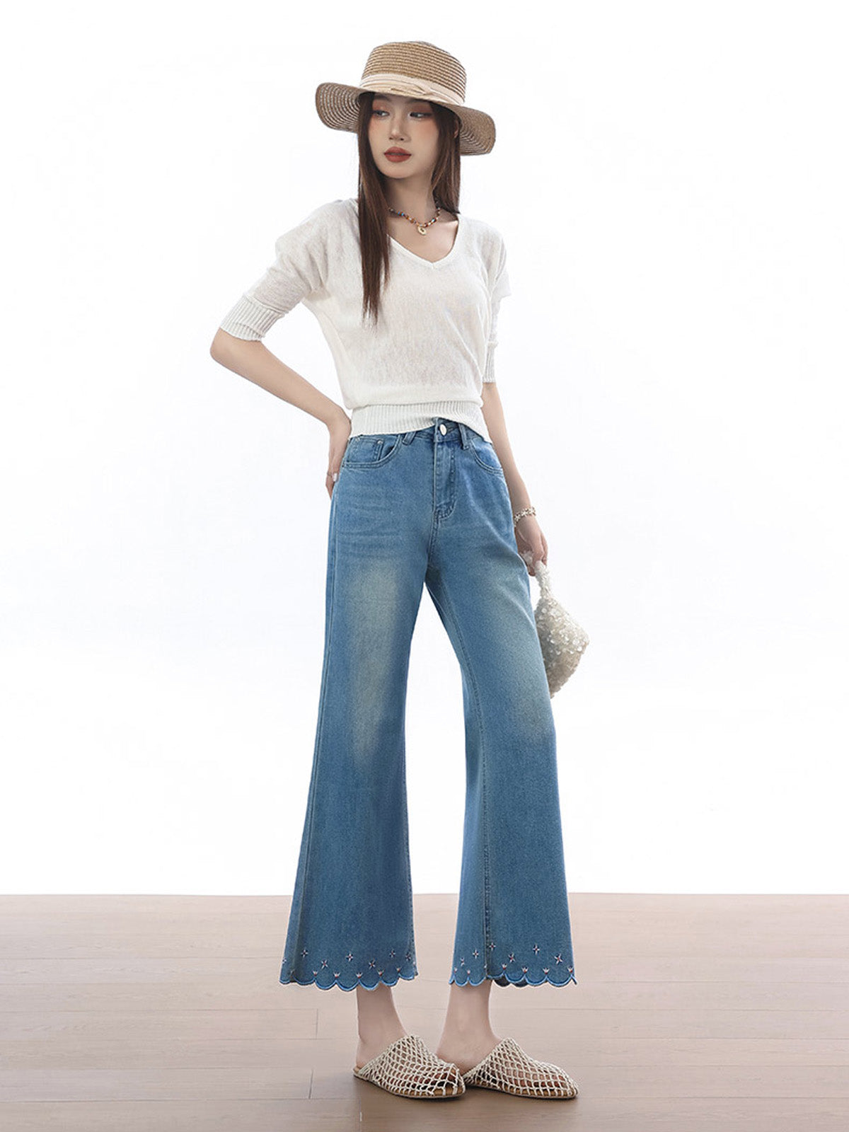 High rise light blue flared jeans with scalloped hem and embroidered stars.