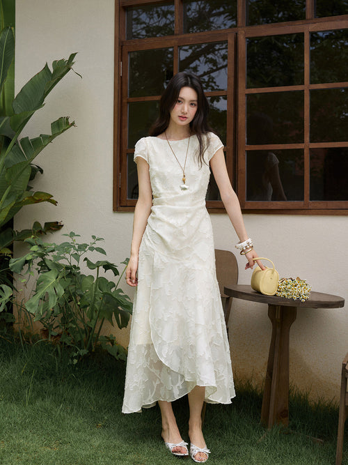 White midi dress with embroidered floral pattern and asymmetrical layered hem.