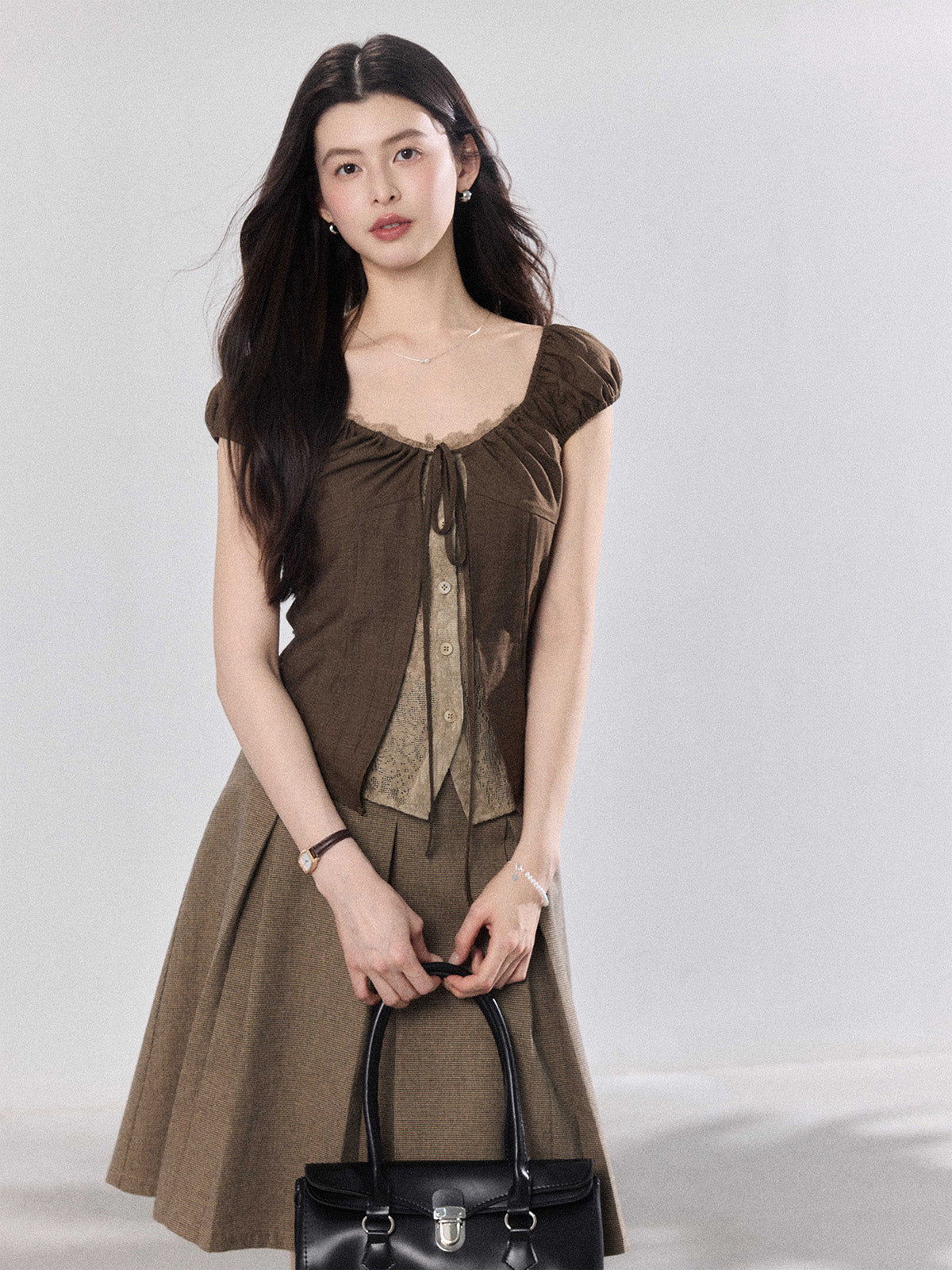Brown puff sleeve top with ruched bust and lace trim.