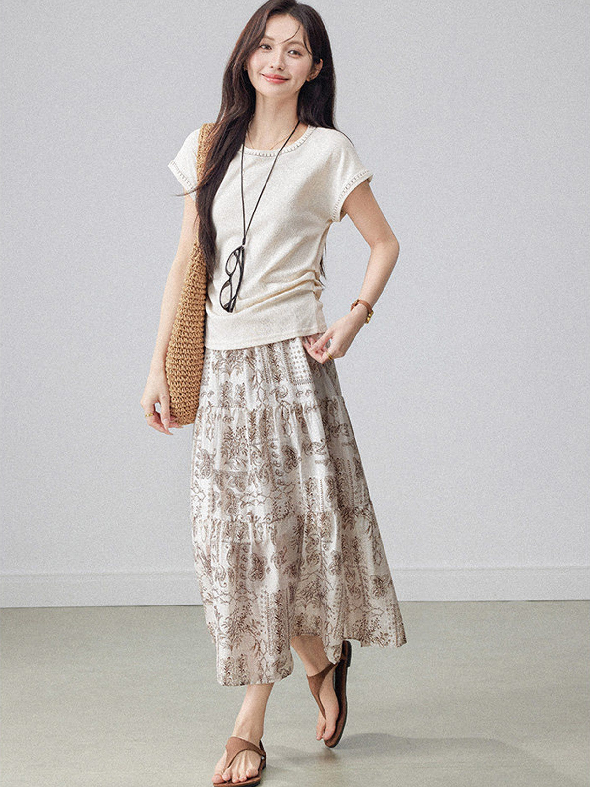 Layered beige paisley skirt featuring an elastic waistband and flared hem.