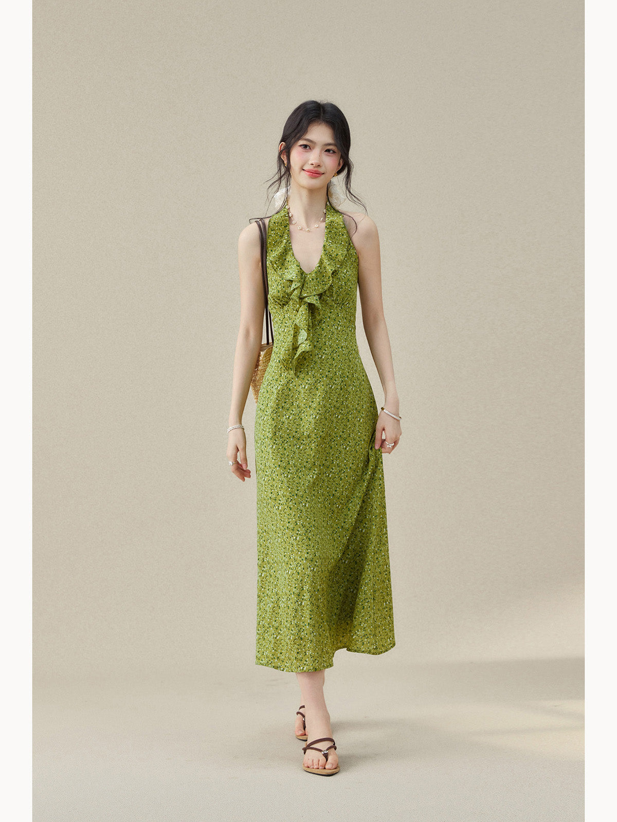 Green floral dress featuring a ruffled detail at the halter neck.