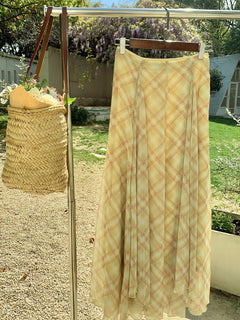Yellow plaid a-line skirt hanging on a rack outdoors