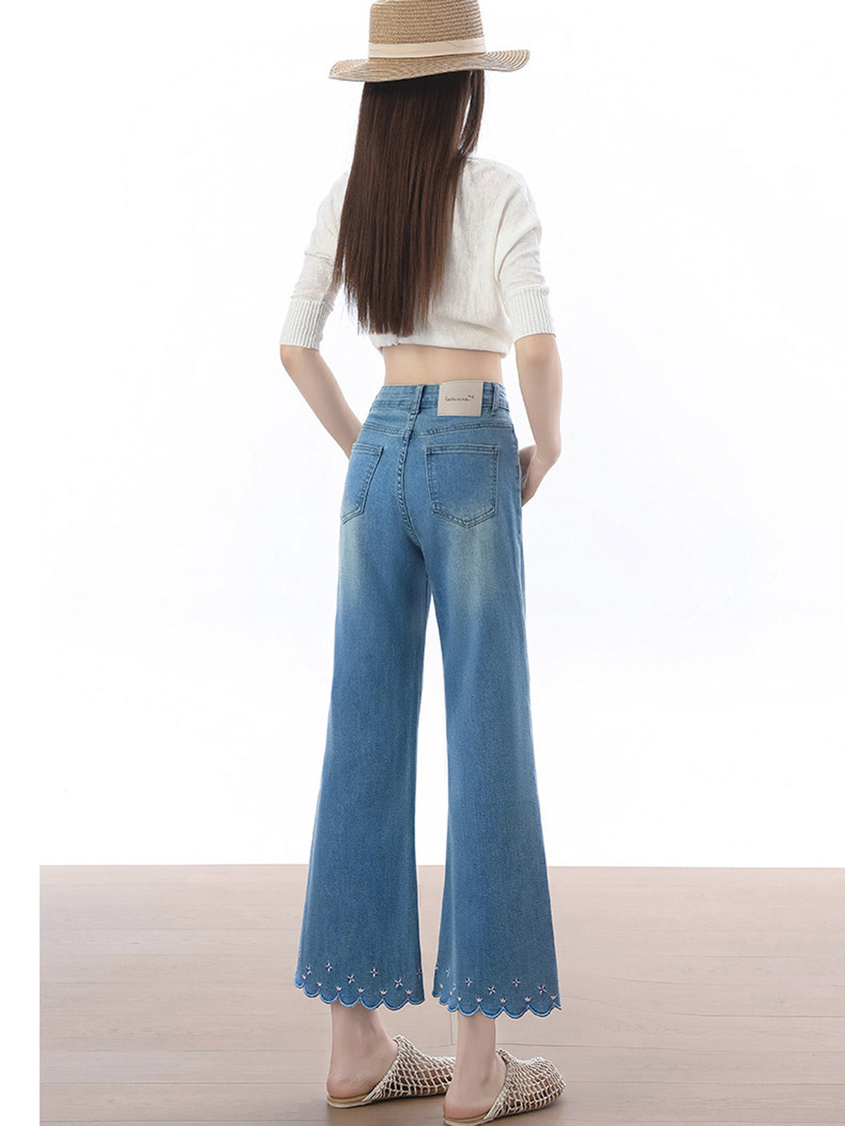 Back view of high rise light blue flared jeans with back waistband label.