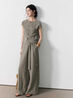 Wide-leg taupe grey pants with a straight hem and tie belt detail.