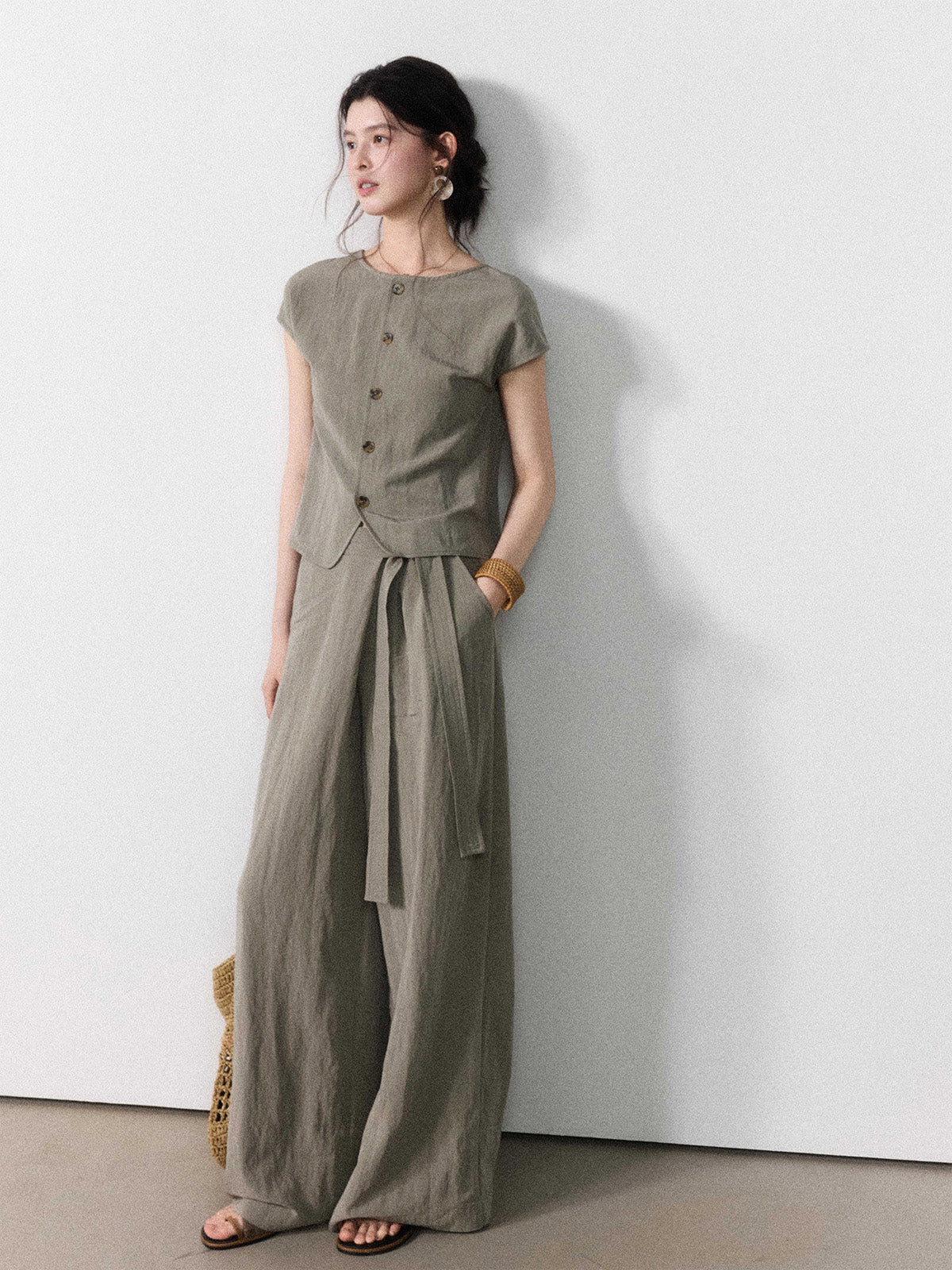 Wide-leg taupe grey pants with a straight hem and tie belt detail.