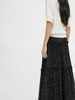 Back view of black floral A-line skirt with layered ruffles and sheer overlay