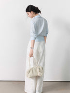 Three-quarter sleeve light blue blouse with gathered waist.