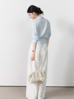 Three-quarter sleeve light blue blouse with gathered waist.