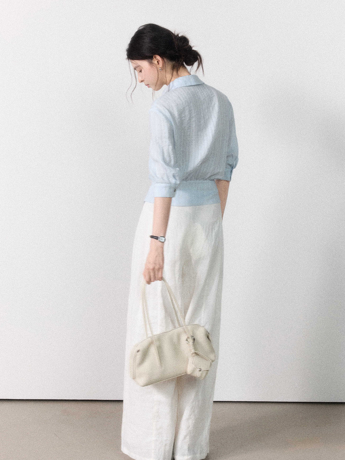 Three-quarter sleeve light blue blouse with gathered waist.
