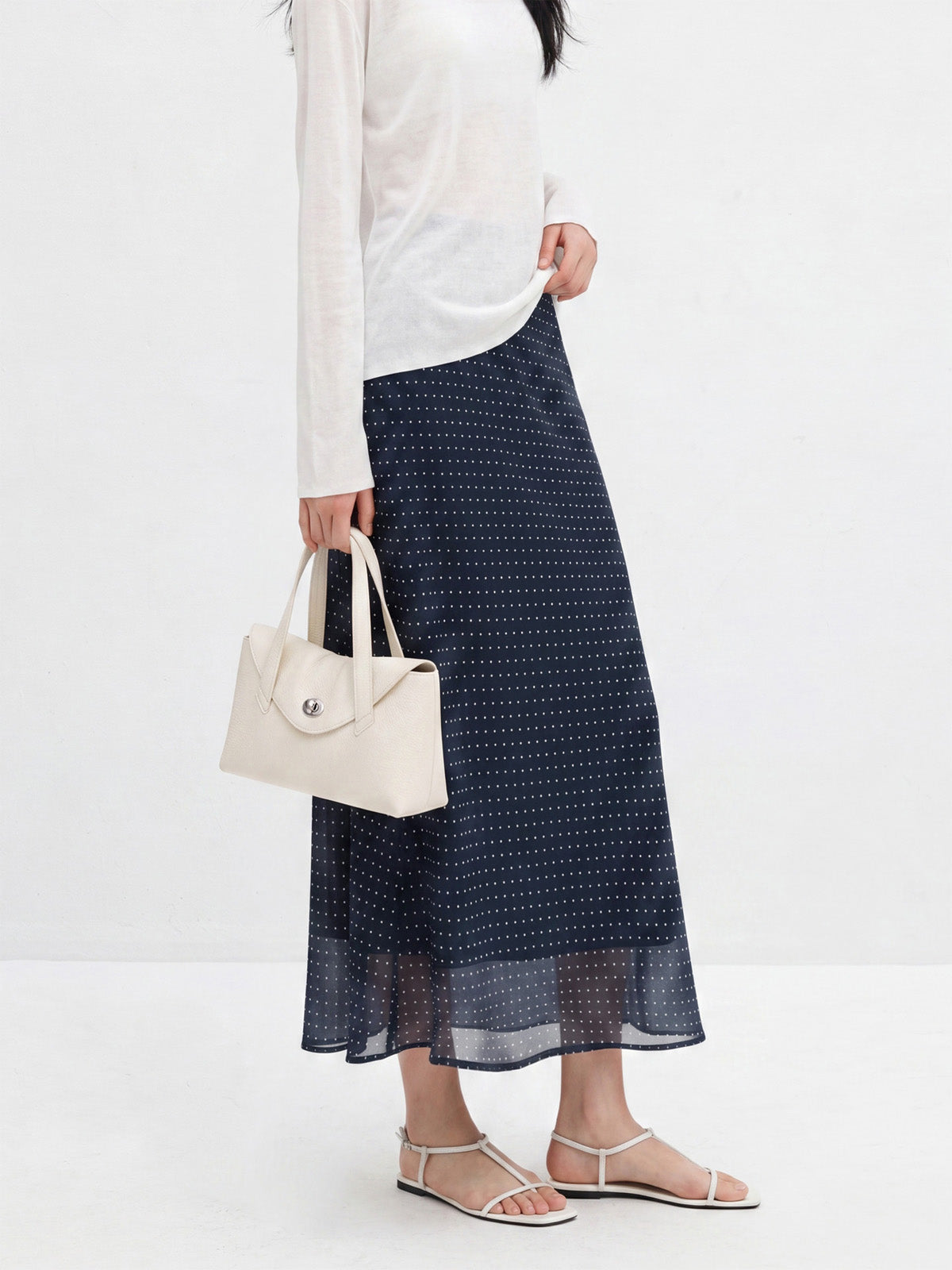 Navy polka dot chiffon skirt featuring a high waist and sheer bottom layer.