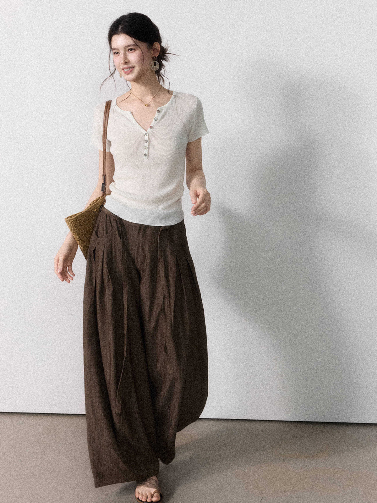 Brown wide-leg pants featuring front pockets and a button closure