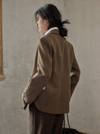 Brown blazer featuring a relaxed fit, double-breasted front, and flap pockets.