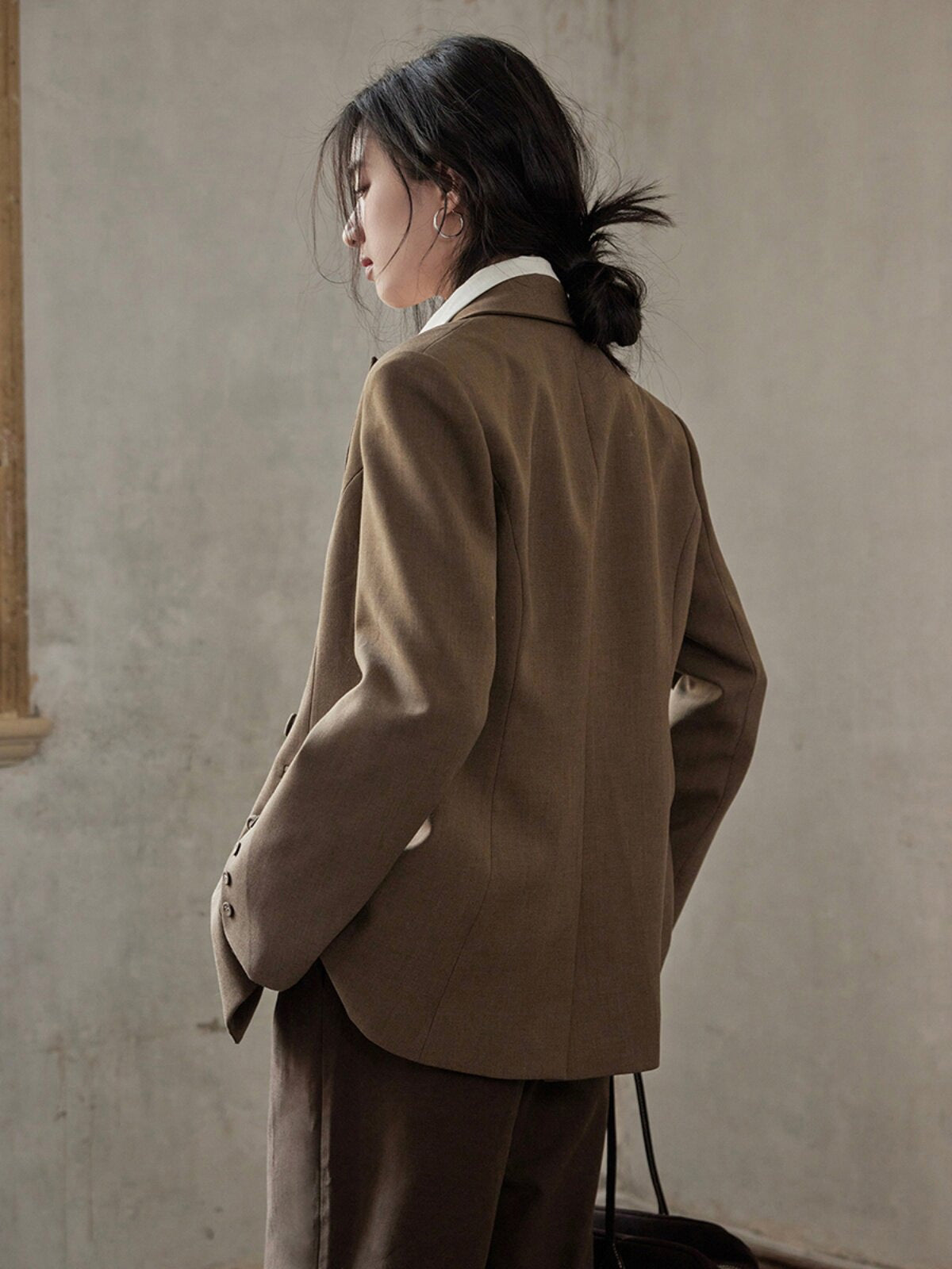 Brown blazer featuring a relaxed fit, double-breasted front, and flap pockets.