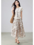 Beige paisley midi skirt with tiered design and flared hem.
