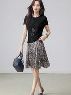 High-waisted leopard print midi skirt featuring an asymmetrical hem and flared silhouette.