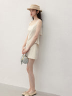 Back view of ivory tank top featuring open back and tie detail.