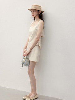 Back view of ivory tank top featuring open back and tie detail.
