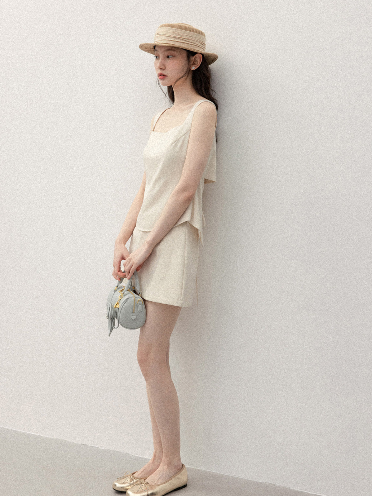 Back view of ivory tank top featuring open back and tie detail.