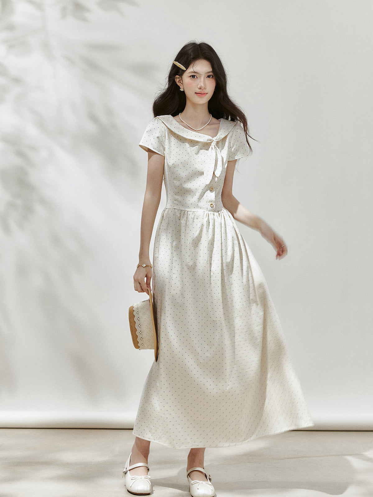Front view of an ivory polka dot midi dress with short sleeves.