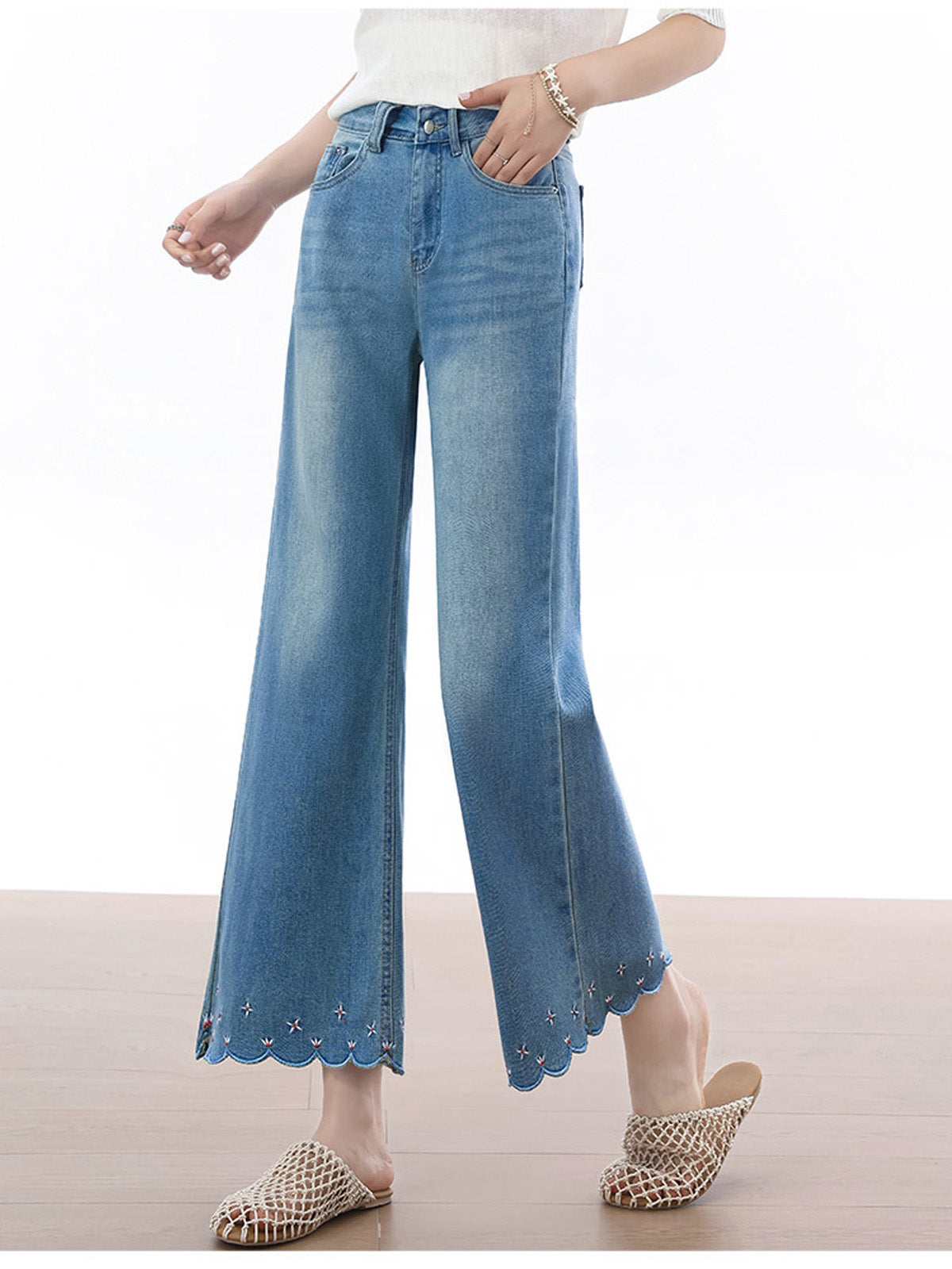 Close-up of front pockets and button fly on light blue flared jeans.