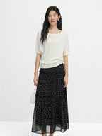 Front view of long black floral skirt featuring tiered construction and gathered waist