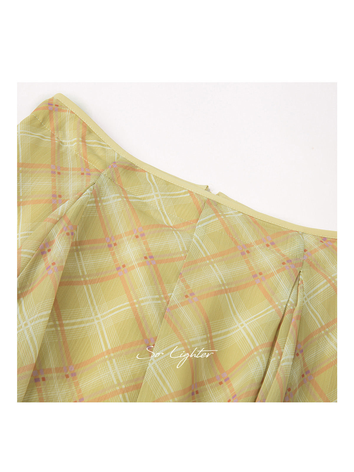 Close-up of yellow plaid skirt with diagonal pattern and pleats
