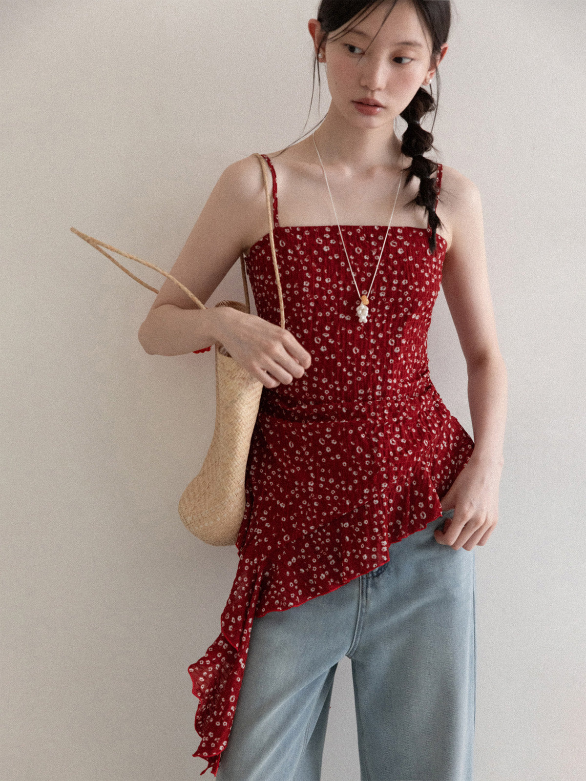 Close-up of red floral tank top with ruched fabric and thin straps.